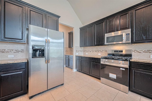 310 Blossom Terrace Ln, Rosenberg, TX 77469 - kitchen featuring stainless steel appliances, vaulted ceiling, backsplash, light tile patterned flooring, and light stone countertops