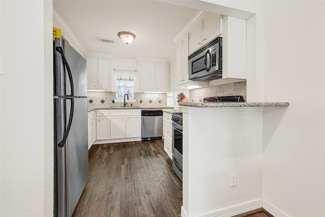 4401 Marina St Unit B, Houston, TX 77007 - kitchen with stainless steel appliances, tasteful backsplash, dark wood-style floors, light stone countertops, and white cabinets