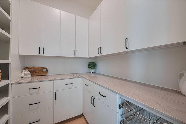 5200 Beech St, Bellaire, TX 77401 - kitchen featuring light stone counters and white cabinets