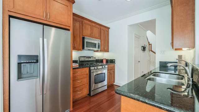 1045 W 16th St, Houston, TX 77008 - kitchen featuring appliances with stainless steel finishes, dark wood-type flooring, crown molding, dark stone countertops, and brown cabinetry