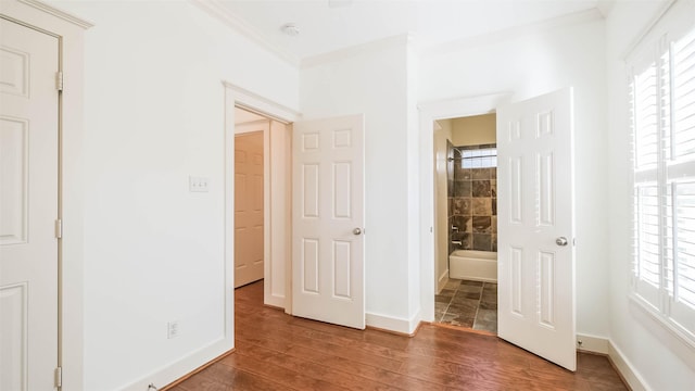 1045 W 16th St, Houston, TX 77008 - unfurnished bedroom with crown molding, wood finished floors, multiple windows, and ensuite bathroom