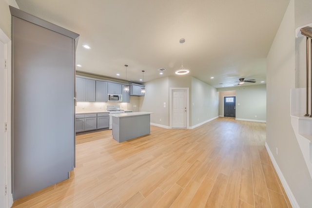 2142 De Soto St, Houston, TX 77091 - kitchen with stainless steel microwave, recessed lighting, ceiling fan, light wood-style floors, and a kitchen island
