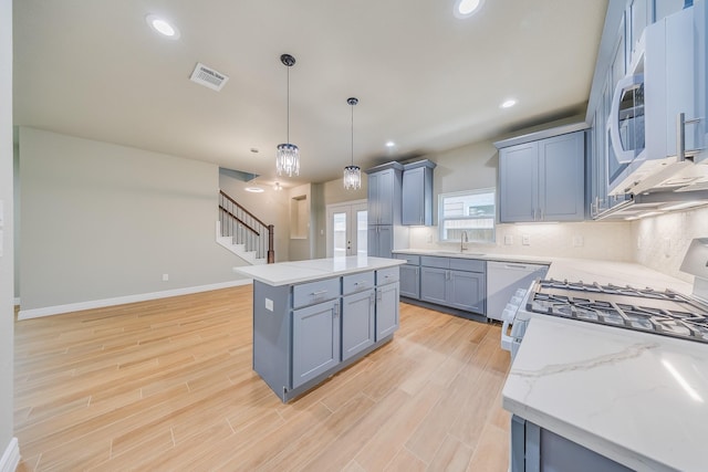 2142 De Soto St, Houston, TX 77091 - kitchen with white appliances, light wood-type flooring, a kitchen island, pendant lighting, and recessed lighting