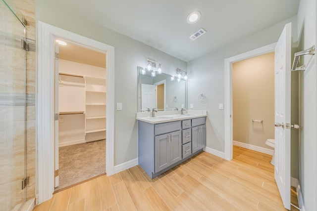 2142 De Soto St, Houston, TX 77091 - full bathroom with double vanity, wood finished floors, a shower stall, a spacious closet, and recessed lighting