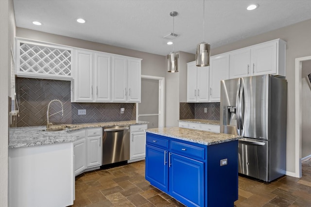 2625 Seashore Dr, Seabrook, TX 77586 - kitchen with appliances with stainless steel finishes, blue cabinets, white cabinets, a kitchen island, and tasteful backsplash