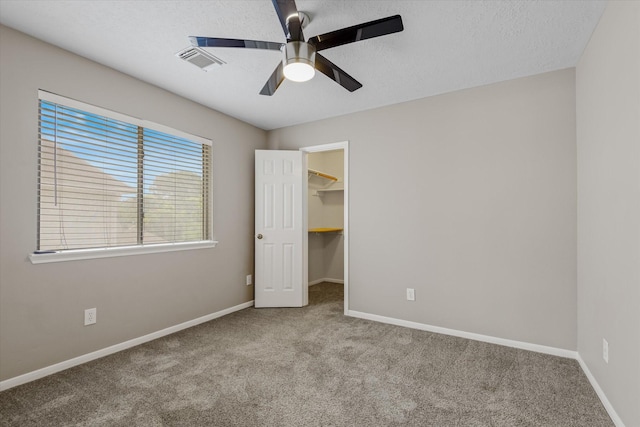 2625 Seashore Dr, Seabrook, TX 77586 - unfurnished bedroom featuring carpet, a walk in closet, ceiling fan, and a textured ceiling