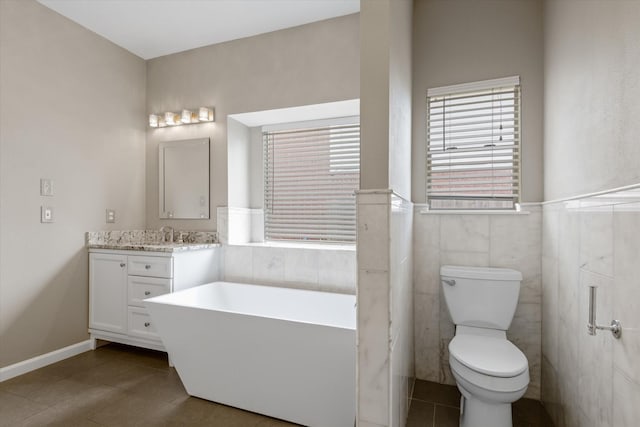 2625 Seashore Dr, Seabrook, TX 77586 - bathroom featuring a soaking tub, vanity, tile patterned flooring, tile walls, and wainscoting