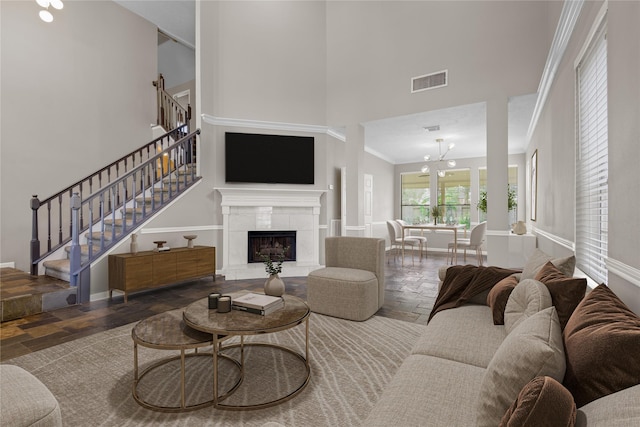 2625 Seashore Dr, Seabrook, TX 77586 - living room featuring a towering ceiling, stone tile flooring, stairway, a chandelier, and a fireplace
