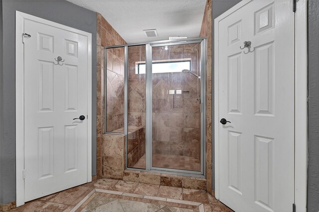 503 Ellingham Dr, Katy, TX 77450 - bathroom featuring a stall shower, inlaid floor details, and a textured ceiling