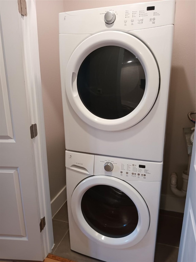 2401 Crawford St Unit A109, Houston, TX 77004 - laundry area featuring stacked washing machine and dryer and tile patterned flooring