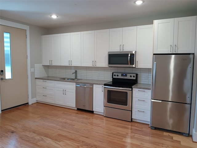 2401 Crawford St Unit A109, Houston, TX 77004 - kitchen featuring stainless steel appliances, white cabinetry, backsplash, and recessed lighting