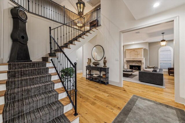 5001 Wedgewood Dr, Bellaire, TX 77401 - staircase with wood finished floors, a fireplace with raised hearth, and arched walkways