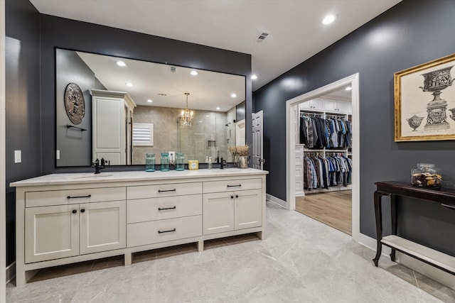 5001 Wedgewood Dr, Bellaire, TX 77401 - full bath featuring a stall shower, double vanity, a chandelier, a spacious closet, and recessed lighting