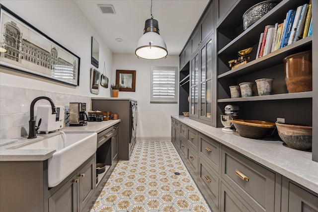 5001 Wedgewood Dr, Bellaire, TX 77401 - bar with washer and clothes dryer, backsplash, pendant lighting, and light tile patterned floors