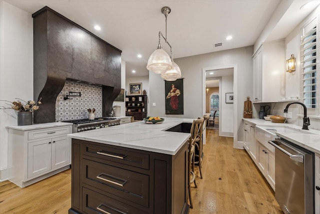 5001 Wedgewood Dr, Bellaire, TX 77401 - kitchen featuring stainless steel dishwasher, a kitchen island, backsplash, light stone counters, and recessed lighting