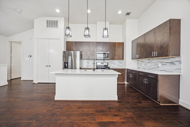 3208 N Macgregor Way Unit C, Houston, TX 77004 - kitchen featuring appliances with stainless steel finishes, light countertops, dark brown cabinetry, backsplash, and a center island with sink