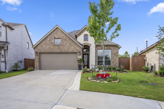 23007 Birchwood Valley Ln, Katy, TX 77493 - french country home featuring brick siding, driveway, and a garage