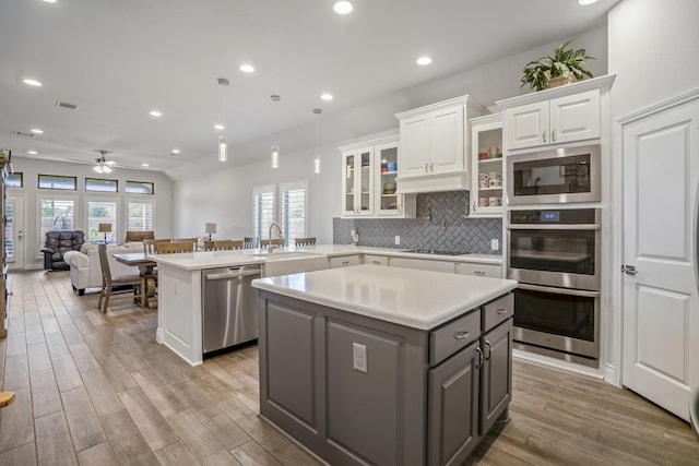 23007 Birchwood Valley Ln, Katy, TX 77493 - kitchen with stainless steel appliances, a kitchen island, white cabinets, a peninsula, and recessed lighting