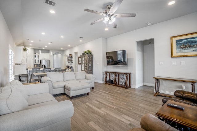 23007 Birchwood Valley Ln, Katy, TX 77493 - living room with arched walkways, light wood-style flooring, a ceiling fan, and recessed lighting
