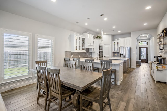 23007 Birchwood Valley Ln, Katy, TX 77493 - dining space featuring arched walkways, plenty of natural light, dark wood finished floors, and recessed lighting