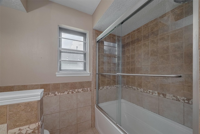 5711 Arenas Timbers Dr, Humble, TX 77346 - bathroom with bath / shower combo with glass door, tile walls, and a wainscoted wall