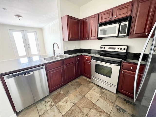 7575 Kirby Dr Unit 1203, Houston, TX 77030 - kitchen featuring stainless steel appliances, reddish brown cabinets, stone tile floors, dark countertops, and a peninsula