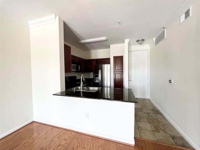 7575 Kirby Dr Unit 1203, Houston, TX 77030 - kitchen featuring fridge with ice dispenser, stainless steel microwave, a peninsula, dark countertops, and dark brown cabinets