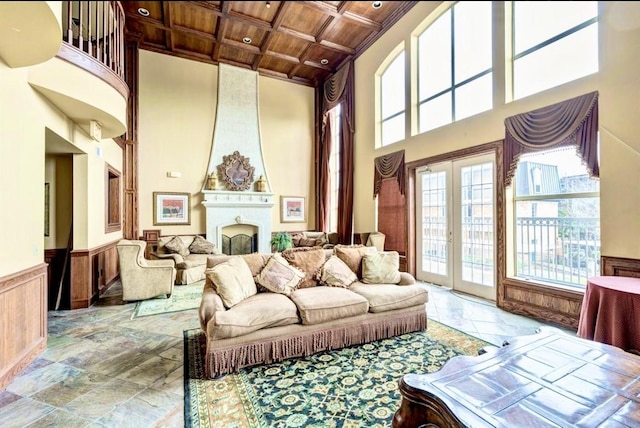7575 Kirby Dr Unit 1203, Houston, TX 77030 - living area with a wood ceiling with exposed beams, a towering ceiling, a wainscoted wall, a large fireplace, and coffered ceiling