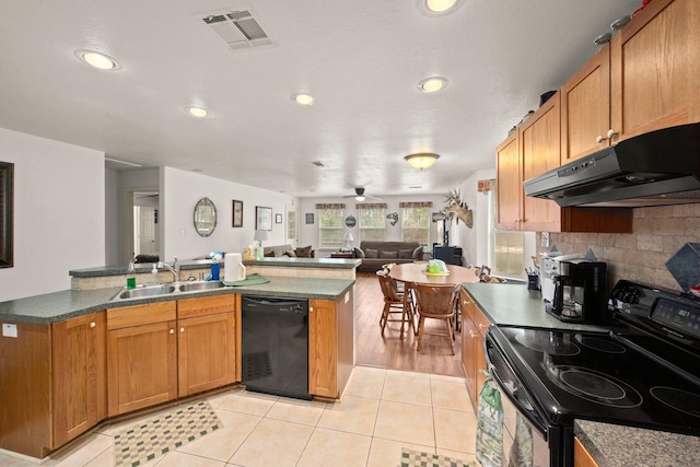 164 Sea Gull Dr, Livingston, TX 77351 - kitchen with electric stove, black dishwasher, under cabinet range hood, light tile patterned floors, and open floor plan