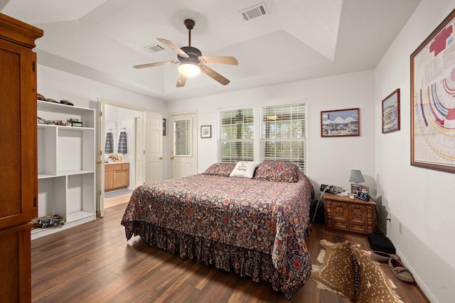164 Sea Gull Dr, Livingston, TX 77351 - bedroom with wood finished floors, a raised ceiling, a ceiling fan, and ensuite bath