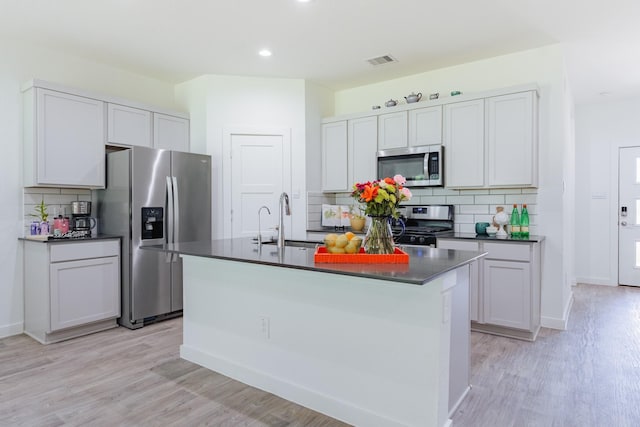 14205 Wonder Lake Ln, Conroe, TX 77384 - kitchen with stainless steel appliances, dark countertops, tasteful backsplash, light wood-style flooring, and recessed lighting