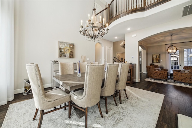 13627 Saddlebred Springs Ln, Cypress, TX 77429 - dining space featuring a chandelier, arched walkways, dark wood-type flooring, a high ceiling, and stairway