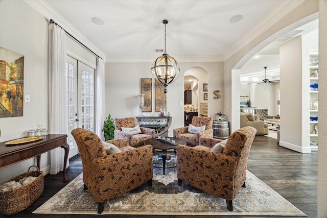 13627 Saddlebred Springs Ln, Cypress, TX 77429 - living area featuring arched walkways, a ceiling fan, dark wood-style flooring, crown molding, and a chandelier