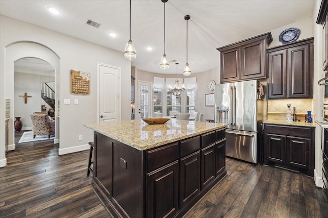 13627 Saddlebred Springs Ln, Cypress, TX 77429 - kitchen featuring high quality fridge, dark wood-type flooring, a center island, light stone countertops, and backsplash