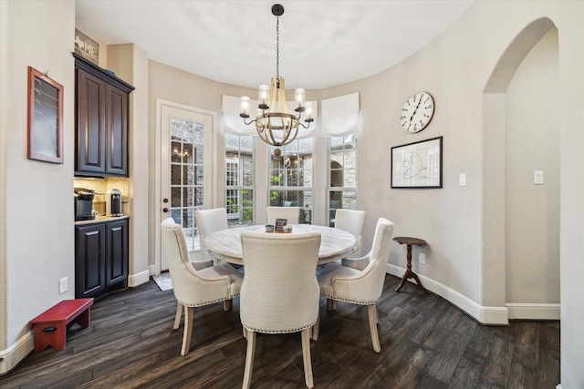 13627 Saddlebred Springs Ln, Cypress, TX 77429 - dining area featuring dark wood-type flooring, a chandelier, and arched walkways