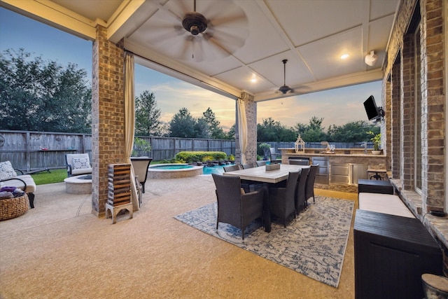 13627 Saddlebred Springs Ln, Cypress, TX 77429 - fenced backyard with an outdoor kitchen, a ceiling fan, a patio area, and an outdoor fire pit