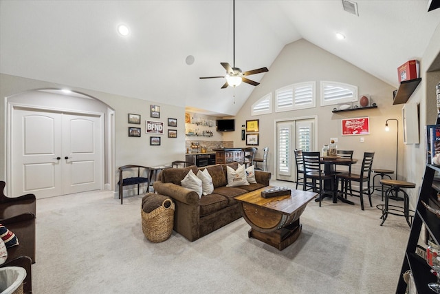 13627 Saddlebred Springs Ln, Cypress, TX 77429 - living area with light colored carpet, wet bar, arched walkways, high vaulted ceiling, and ceiling fan