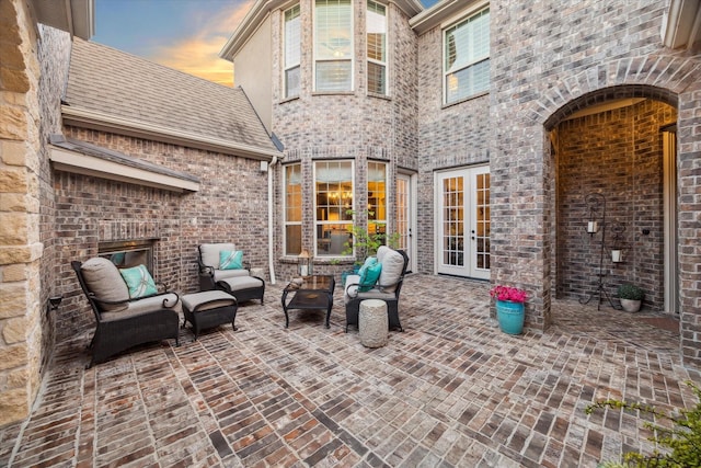 13627 Saddlebred Springs Ln, Cypress, TX 77429 - patio terrace at dusk with french doors, a patio, and an outdoor hangout area