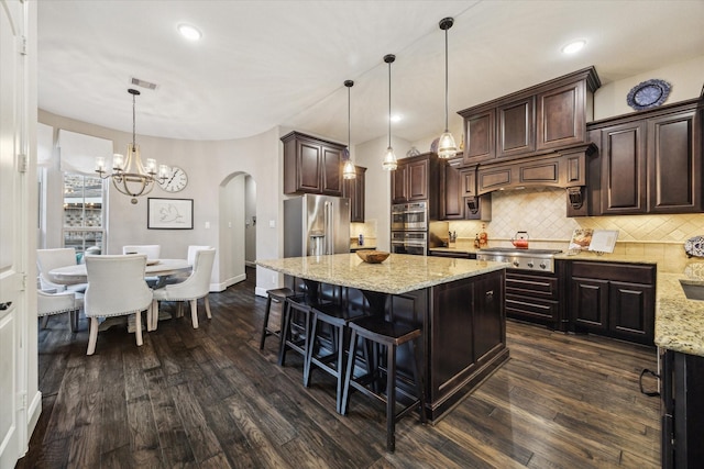 13627 Saddlebred Springs Ln, Cypress, TX 77429 - kitchen with stainless steel appliances, arched walkways, dark wood-type flooring, dark brown cabinetry, and recessed lighting
