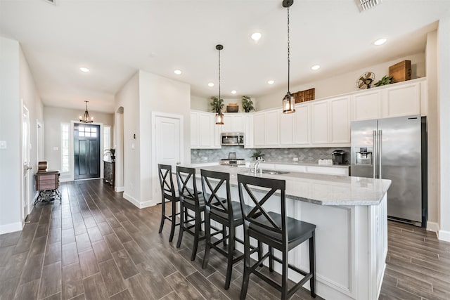 10119 Napier Dr, Iowa Colony, TX 77583 - kitchen with appliances with stainless steel finishes, dark wood-type flooring, white cabinetry, an island with sink, and recessed lighting