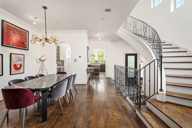 1616 Nevada St, Houston, TX 77006 - dining room with arched walkways, wood finished floors, ornamental molding, and stairs