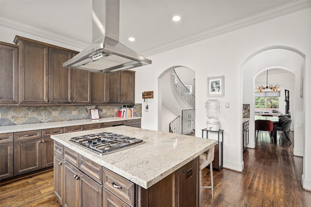 1616 Nevada St, Houston, TX 77006 - kitchen featuring island exhaust hood, stainless steel gas stovetop, arched walkways, dark wood-style floors, and crown molding