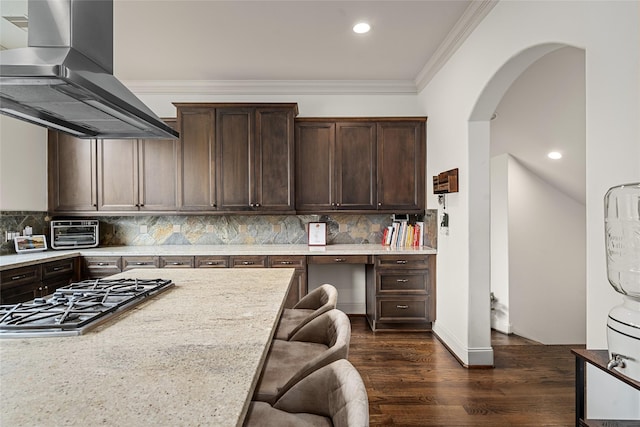 1616 Nevada St, Houston, TX 77006 - kitchen with exhaust hood, stainless steel gas stovetop, dark brown cabinets, arched walkways, and tasteful backsplash