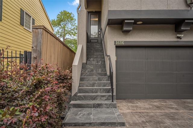1616 Nevada St, Houston, TX 77006 - doorway to property featuring stucco siding, a garage, and driveway