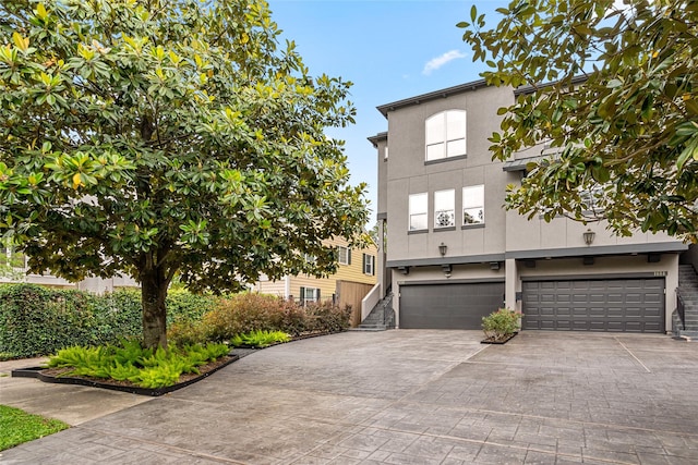 1616 Nevada St, Houston, TX 77006 - view of front of property featuring stucco siding, a garage, and driveway