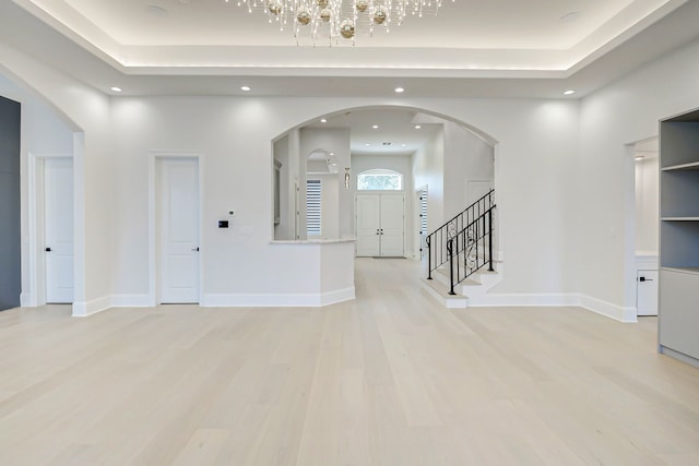 2822 Westgrove Ln, Houston, TX 77027 - unfurnished room with light wood-type flooring, a tray ceiling, recessed lighting, stairs, and a chandelier