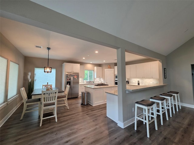 26804 Vista Meadow Ct, Huffman, TX 77336 - kitchen with appliances with stainless steel finishes, white cabinets, dark wood-style flooring, decorative backsplash, and a center island