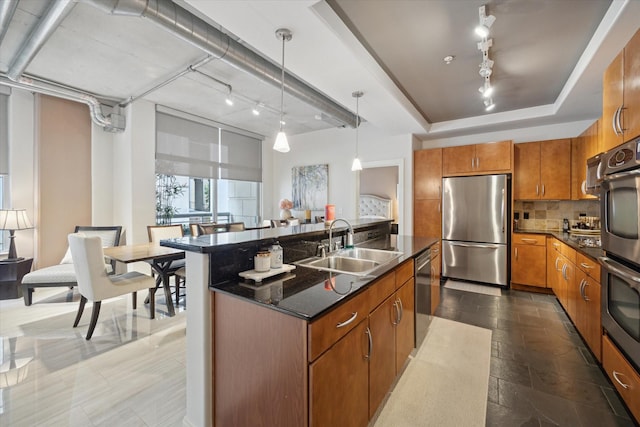 1901 Post Oak Blvd Unit 202, Houston, TX 77056 - kitchen featuring stainless steel appliances, brown cabinetry, tasteful backsplash, a kitchen island with sink, and hanging light fixtures
