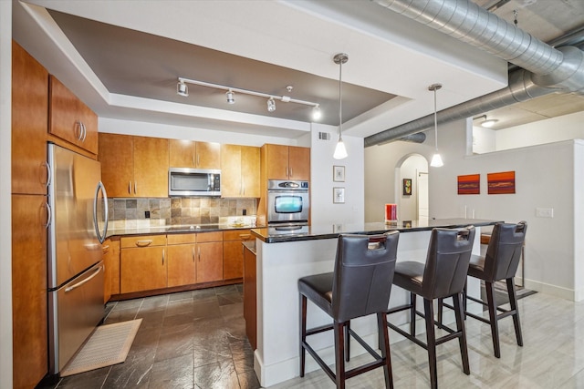 1901 Post Oak Blvd Unit 202, Houston, TX 77056 - kitchen with stainless steel appliances, a raised ceiling, arched walkways, and decorative backsplash