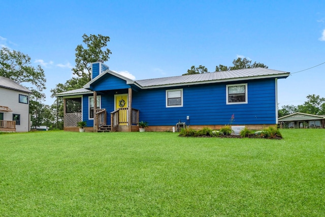 150 Lazy Ln, Livingston, TX 77351 - view of front of property with a front yard, a chimney, and a metal roof